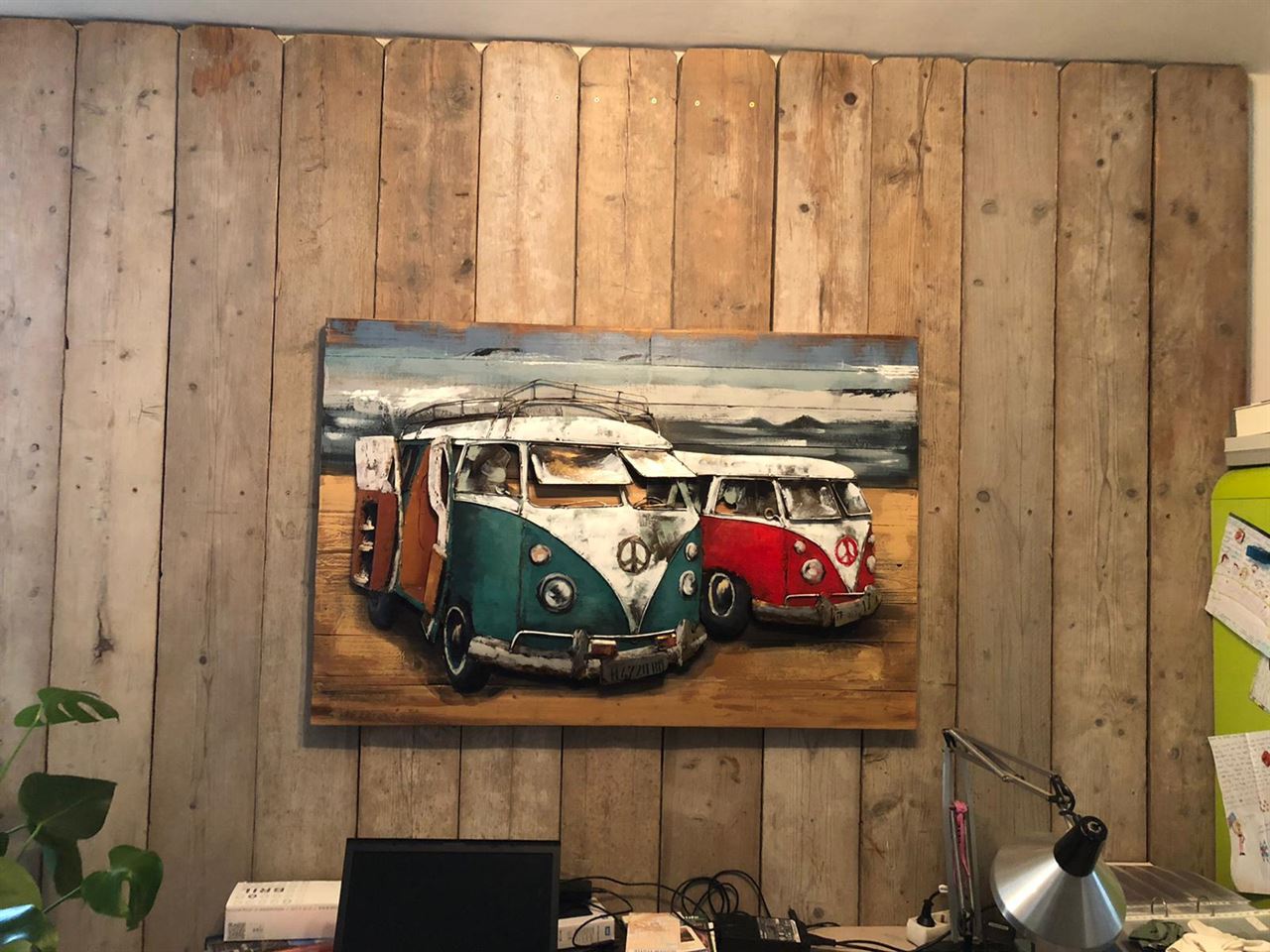 Wand gemaakt van gebruikte steigerplanken met kunstwerk van ons VW bussen.